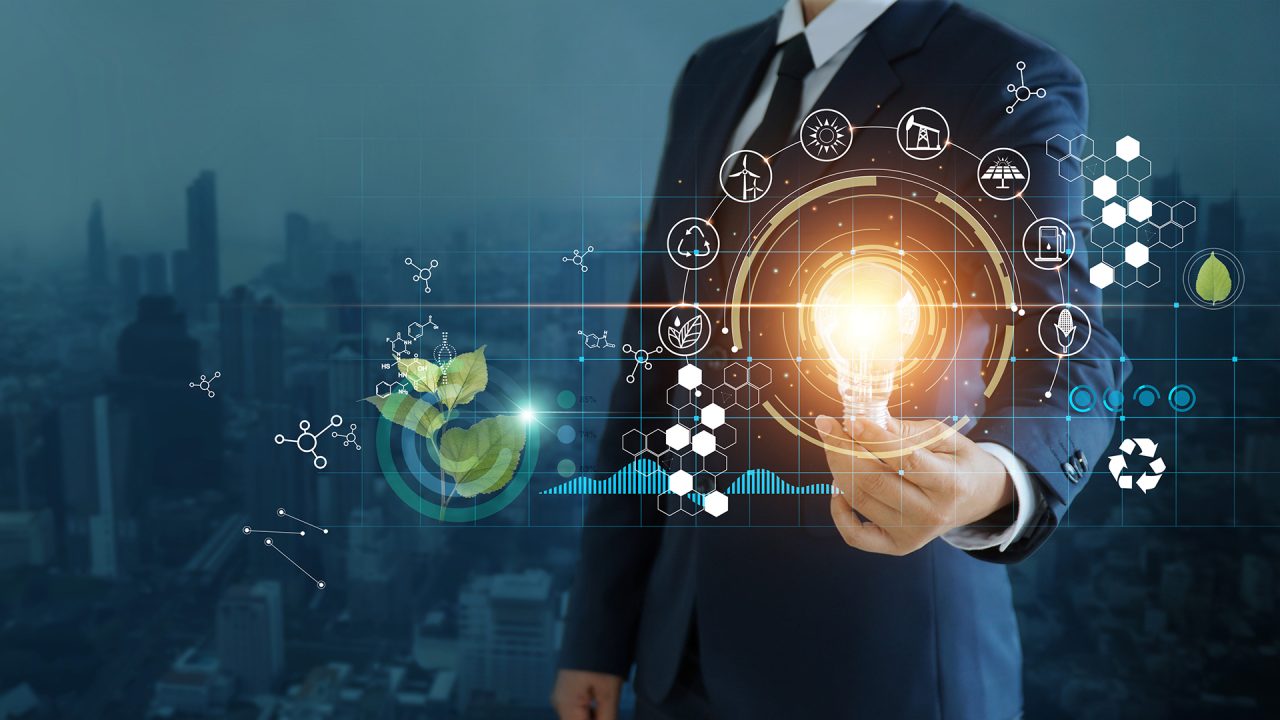 businessman holding light bulb against nature on city background  with icons energy sources for renewable, sustainable development,  Ecology and renewable energy concept.